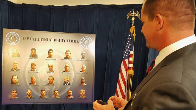 Putnam County Sheriff Gator DeLoach looks at the arrest photos of the 21 men arrested in Jacksonville in Operation Watchdog, which involved staff from several law enforcement agencies. (Dan Scanlan/Florida Times-Union)