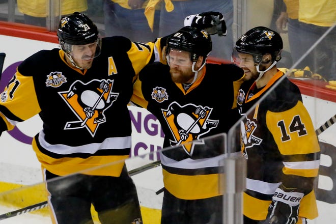 Pittsburgh Penguins' Phil Kessel, center, celebrates with teammates Evgeni Malkin (71) and Chris Kunitz (14) after scoring against the Ottawa Senators during the third period of Game 2 of the Eastern Conference final in the NHL hockey Stanley Cup playoffs, Monday, May 15, 2017, in Pittsburgh. (AP Photo/Gene J.Puskar)