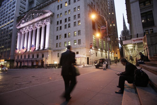 FILE - In this Oct. 8, 2014, file photo, a man walks to work on Wall Street, near the New York Stock Exchange, in New York. Shares edged higher Monday, May 15, 2017, in Europe and Asia, despite worries of disruptions from the "WannaCry" ransomware cyberattack over the weekend. THE ASSOCIATED PRESS