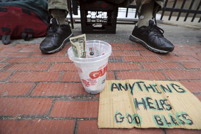 In this Wednesday, May 10 photo, D. Rogers, a homeless man, panhandles for change in Portland, Maine. The city recently began a program to offer day jobs cleaning up parks and other light labor jobs to panhandlers for $10.68 an hour. [AP Photo/Robert F. Bukaty]