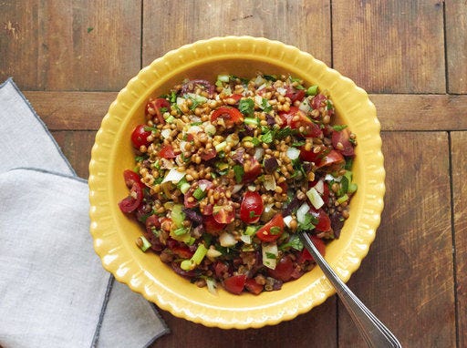 This December 2016 photo shows a Mediterranean tomato wheat berry salad with fresh herbs in New York. This dish is from a recipe by Katie Workman. (Mia via AP)