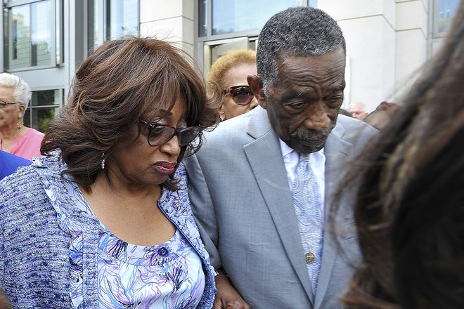 FILE - In this May 11, 2017, file photo, Bishop Rudolph W. McKissick, Sr., right, escorts former U.S. Rep. Corrine Brown outside the courthouse in Jacksonville, Fla. Brown was found guilty of taking money from a charity that was purported to be giving scholarships to poor students. A juror dismissed during deliberations in Brown's fraud trial in Florida told his colleagues that the "Holy Spirit" told him she was not guilty, according to a court transcript. The transcript released Monday, May 15, provided new details into why the unidentified juror was released during deliberations after another juror raised concerns over the comments. (Bruce Lipsky/The Florida Times-Union via AP, File)