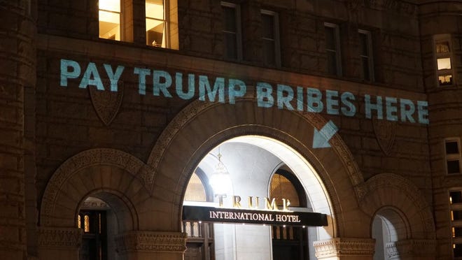 Activists project phrases and the emoluments clause on the Trump International Hotel in Washington, D.C.