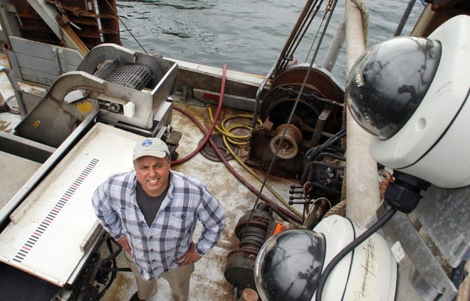 Fisherman Chris Brown looks up at two of the cameras he has on board his boat the Proud Mary. The cameras are at far right in the foreground with clear glass protective covers./ Bob Breidenbach/

The Providence Journal