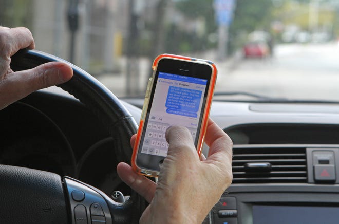 Illegal texting on an iPhone in car. [THE PROVIDENCE JOURNAL, FILE/STEVE SZYDLOWSKI]