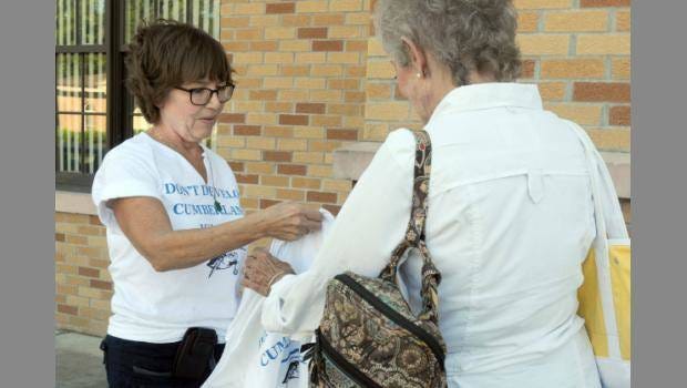 Alex Kearns, chairwoman of St. Marys Earthkeepers, hands out Don’t Develop Cumberland Island T-shirts before a Camden County Commission meeting in Woodbine on Tuesday night. (Terry Dickson/Florida Times-Union)