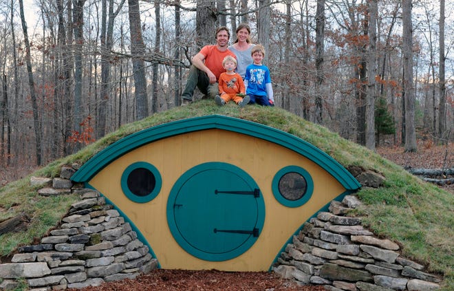 In this undated photo provided by Wooden Wonders, Rocy and Melissa Pillsbury and their children sit atop a custom Hobbit House in Santa Fe, Tenn. (Jonathan Giffin via AP)