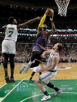 Cleveland Cavaliers forward LeBron James (23) drives between Boston Celtics forward Jaylen Brown, left, and center Kelly Olynyk during the first quarter of Game 1 of the NBA basketball Eastern Conference finals, Wednesday, May 17, 2017, in Boston. (AP Photo/Charles Krupa)