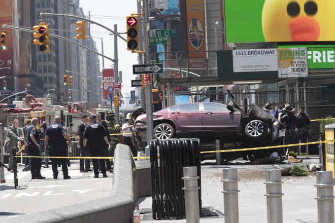 A car rests on a security barrier in New York's Times Square after driving through a crowd of pedestrians, injuring at least a dozen people, Thursday, May 18, 2017. THE ASSOCIATED PRESS
