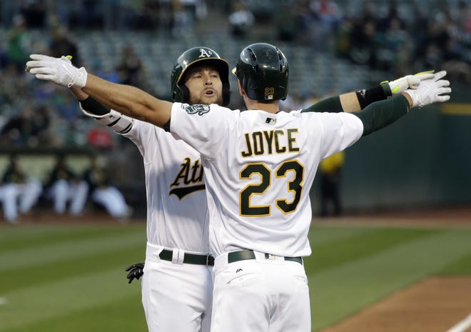 Oakland's Jed Lowrie, left, celebrates his two-run home run at the plate with teammate Matt Joyce during Thursday night's game. The A's won 8-3.