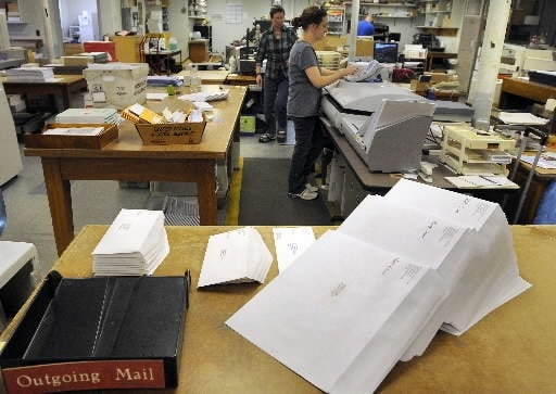 Large acceptance letters and small rejection letters for prospective college students wait to be mailed. [Tom Rettig/Telegram & Gazette]