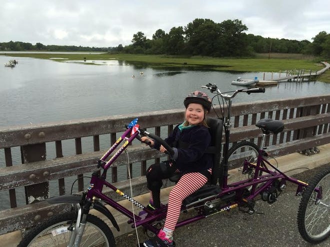 Talia Duff rides on her tandem bike at the end of Labor in Vain Road during the summer of 2016. [Courtesy photo]