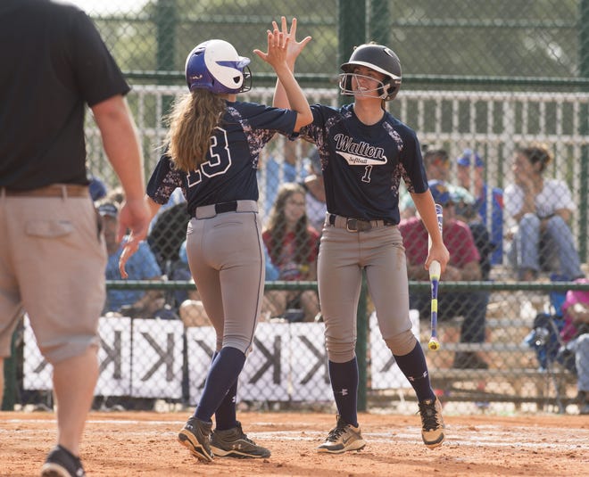 Walton's Sydni Earley, left, celebrates with teammate Jamie Lamb at home plate after Lamb scored a run in the fourth inning of their District 5A semifinal game against Coral Springs Charter during the FHSAA Softball State Championships at Historic Dodgertown in Vero Beach on Friday. [HOBIE HILER/SPECIAL TO THE DAILY NEWS]