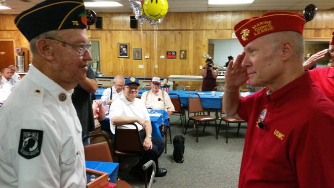 World War II veteran Vince Bolevich, left, is saluted by George Wanberg, commandaner of the Marine Corps League, on Wednesday during his 100th birthday celebration. [Millard K. Ives / Daily Commercial]