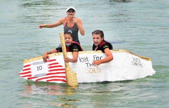 Valerie Sierra Mundo and Lilly Chouinard try to keep their boat, Float For The Gold, from capsizing during Destin Middle School's 20th annual Cardboard Boat Race held Friday at Clement Taylor Park in Destin. [DEVON RAVINE/THE LOG]