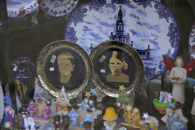 In this photo taken May 4, china plates with images of Francisco and Jacinta Marto are displayed for sale in a shop window in Fatima, Portugal. Pope Francis visited the Fatima shrine on May 12 and 13 to canonize Francisco and Jacinta Marto, two Portuguese shepherd children who said they saw visions of the Virgin Mary 100 years ago. [AP Photo/Armando Franca]