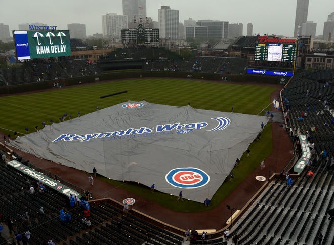 A tarp covers the field during a rain delay in the sixth inning of a baseball game between the Chicago Cubs and the Milwaukee Brewers, Friday, May, 19, 2017, in Chicago. (AP Photo/David Banks)