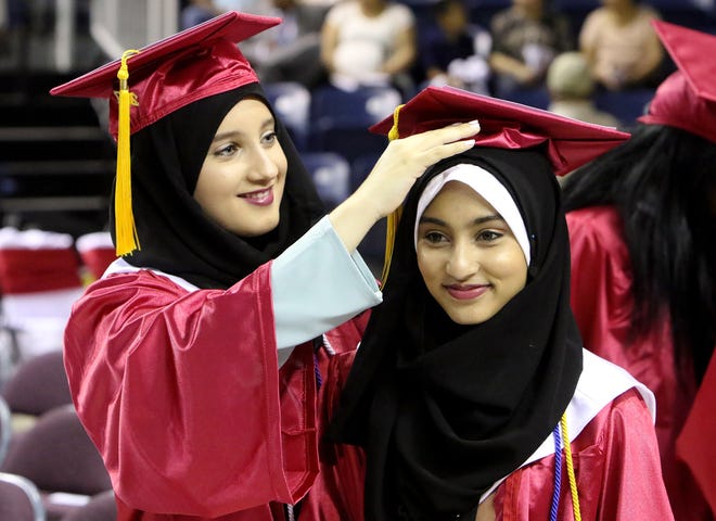 Raefa Yasin, left, helps Madiha Alam with her mortar board Friday, May 19, 2017, before Northside High School's 131st Commencement excercise at the Stubblefield Center on the UAFS campus. Madiha is the 17-year-old daughter of Rubina Baig and Mansoor Alam and Raefa is the 17-year-old daughter of Nibal and Hisham Yasin. [JAMIE MITCHELL/TIMES RECORD]