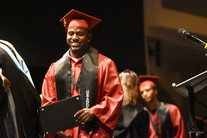 A Goodwill High School student accepts his diploma with a big smile during Friday's commencement ceremony at High Desert Church in Victorville. [David Pardo, Daily Press]