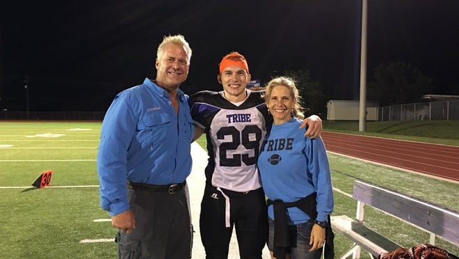 Former NFL offensive lineman Bruce Collie, left, stands with his son Cameron, center, and wife, Holly, after one of Cameron’s football games with the Bastrop Tribe last fall. The Collies have home-schooled their 13 children, and they support a Texas Senate bill that would give home-schooled students a chance to participate in public school athletics. COURTESY PHOTO