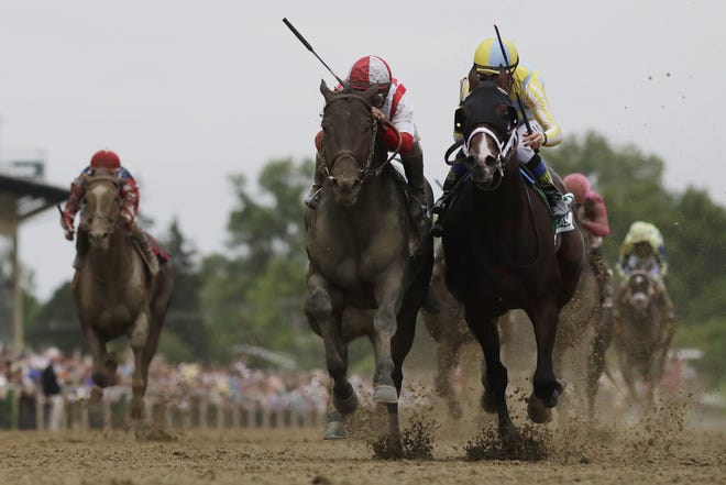Cloud Computing, second from left, ridden by Javier Castellano, wins the 142nd Preakness Stakes horse race ahead of Classic Empire, ridden by Julien Leparoux, Saturday at Pimlico Race Course in Baltimore. [MIKE STEWART / ASSOCIATED PRESS]