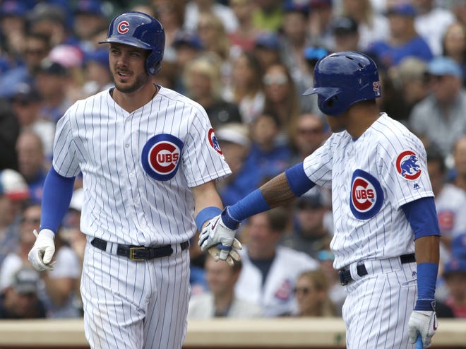 The Chicago Cubs' Kris Bryant, left, celebrates with Addison Russell after scoring on a sacrifice fly by Willson Contreras in the first inning of Sunday's game against the Milwaukee Brewers in Chicago. [AP Photo/Nam Y. Huh]