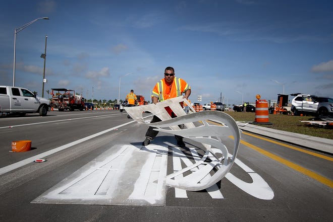Crews complete the final touches of Florida's first diverging diamond traffic pattern at the University Parkway and Interstate 75 interchange before it officially opened at noon Sunday. The $74.5 million project is about three weeks ahead of schedule. [Herald-Tribune photo / Matt Houston]