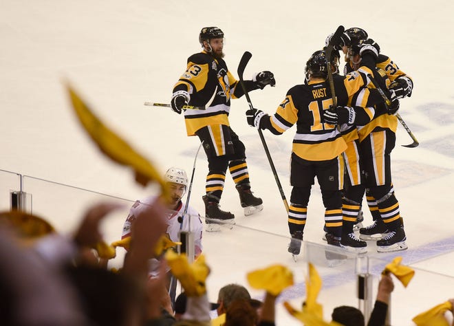 The Penguins' Nick Bonino (13) joins Bryan Rust (17) and Carter Rowney (37) as they celebrate with Olli Maata after his goal during the first period of Game 5 of the Eastern Conference Finals on Sunday at PPG Paints Arena in Pittsburgh.