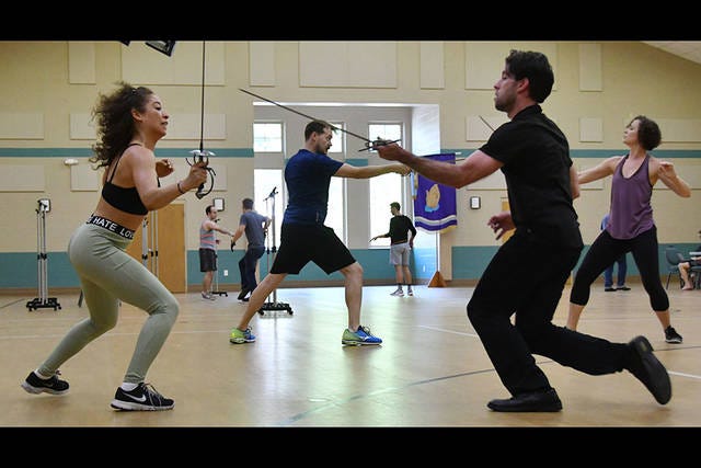 EN GARDE — Meagan Smith and E.J. Cantu (front pair), along with others, participate in stage combat group fight practice at Central United Methodist Church in Asheboro for an upcoming production of ‘The Three Musketeers.’ (Paul Church / The Courier-Tribune)