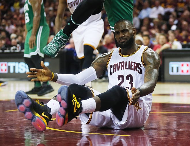 Cleveland Cavaliers forward LeBron James is stepped over by Boston Celtics forward Amir Johnson after being fouled during the second quarter on Sunday night.