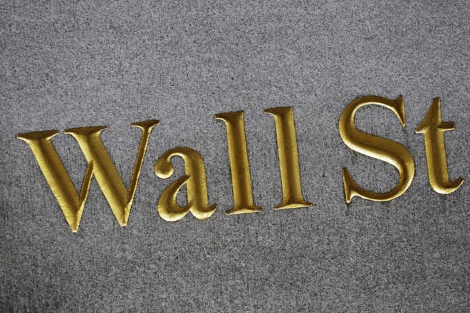 This Monday, July 6, 2015, file photo shows a sign for Wall Street carved into the side of a building in New York. THE ASSOCIATED PRESS