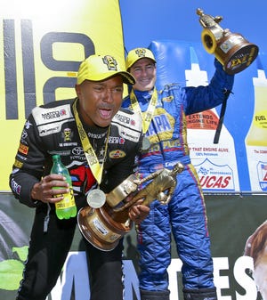 Don Schumacher Racing teammates Atron Brown, left, and Ron Capps celebrate their NHRA Heartland Nationals wins in Top Fuel and Funny Car, respectively, on Sunday. [Chris Neal/The Topeka Capital-Journal via AP]