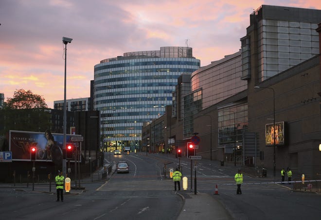 Police stand guard at dawn, after a blast at the Manchester Arena Tuesday, May 23, 2017. An explosion struck an Ariana Grande concert attended by thousands of young fans in northern England Monday night, killing more than a dozen of people and injuring dozens in what police were treating as a terrorist attack. PA VIA AP