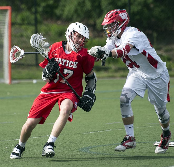 Natick High sophomore Chris Burnes (left) works his way around Waltham High's Zach McDonald during the game at Harding Field in Waltham, May 23, 2017. The Hawks beat the Redhawks, 15-10. [Daily News Staff Photo/John Walker]