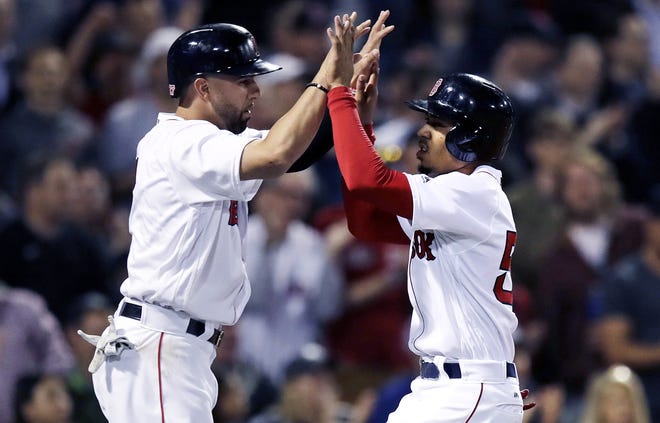 Red Sox outfielder Mookie Bett ( right) and Deven Marrero celebrate after scoring on a single by Xander Bogaerts during the fifth inning of the Red Sox' 11-6 win over the Texas Rangers on Tuesday. [AP Photo/Charles Krupa]