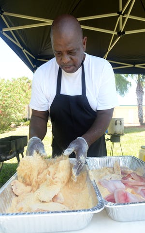 Rodrick Robinson batters up some tilapia during the 2016 May Day Festival of Central Florida presented by the Historic Pughsville Association at the Chain of Lakes Complex in Winter Haven. This year's festival will be held from noon to 4 p.m. at the Southwest Complex Gymnasium, 210 Cypress Gardens Blvd. [SCOTT WHEELER/THE LEDGER (2016)]