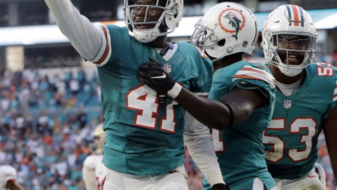 Miami Dolphins cornerback Byron Maxwell (41) is congratulated by outside linebacker Jelani Jenkins (53), and free safety Michael Thomas (31) after Maxwell swatted down a pass intended for San Francisco 49ers wide receiver Torrey Smith (82), during the second half of an NFL football game, Sunday, Nov. 27, 2016, in Miami Gardens, Fla. (AP Photo/Lynne Sladky)