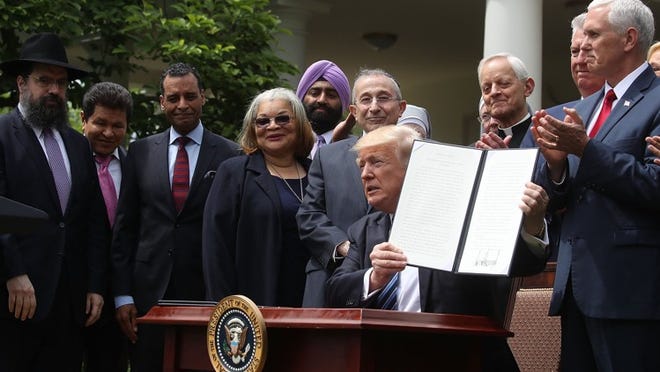 President Donald Trump is flanked by clergy members after signing an Executive Order on Promoting Free Speech and Religious Liberty, during a National Day of Prayer event in the Rose Garden at the White House, on May 4. (Photo by Mark Wilson/Getty Images)