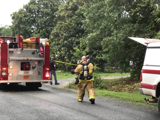 Firemen put up caution tape while others worked ot control a house fire on Ross Road in Cleveland County. [Joyce Orlando/The Star]