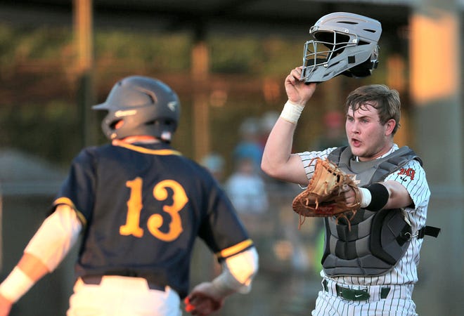Mosley catcher Geoffrey Lancaster (right) argues after tagging Gulf Breeze's Brandon Schrepf (13) during last week's region semifinal game. The Dolphins host Clay tonight in the Region 1-6A Final. [Patti Blake | The News Herald]