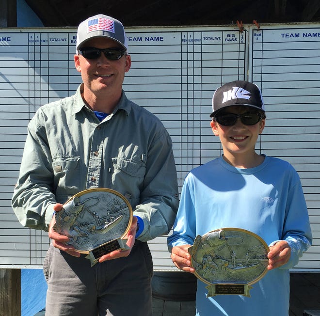 Mike Burns, left, and his son, Lyle, took the first place-trophy in a recent bass fishing tournament on Lake Oconee.
