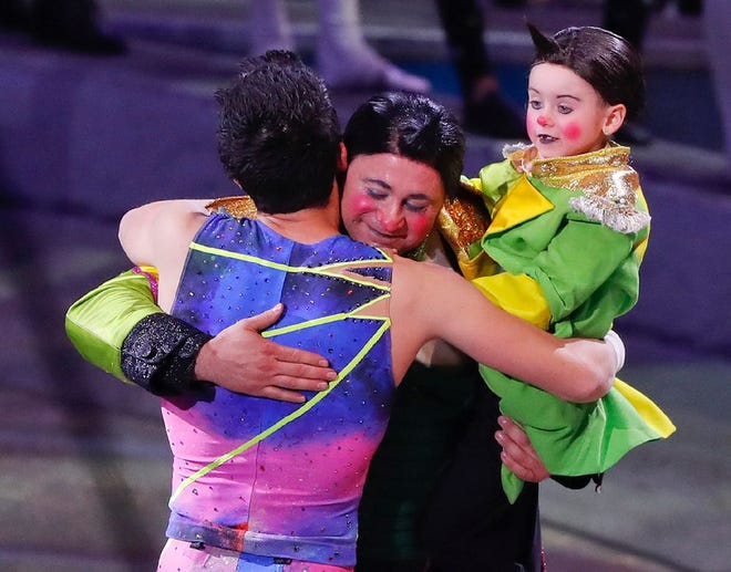 Davis Vassallo, center, hugs a member of the trapeze troupe as he holds his daughter Adriana after the final show of the Ringling Bros. and Barnum & Bailey Circus, May 21 in Uniondale, N.Y. [AP Photo / Julie Jacobson]