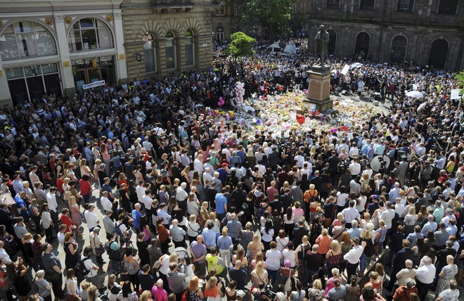 People attend a one minute silence to the victims of Monday's explosion at St Ann's Square in Manchester, England Thursday May 25 2017. More than 20 people were killed in an explosion following a Ariana Grande concert at the Manchester Arena late Monday evening. THE ASSOCIATED PRESS