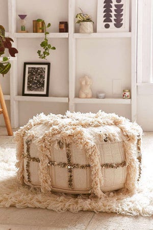 This undated photo provided by Urban Outfitters shows a Moroccan-inspired pouf from Urban Outfitters which sports a shaggy trim, sequins and a geometric motif. (Urban Outfitters/www.urbanoutfitters.com via AP)