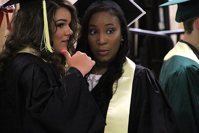 Helena Johnson, left, and Taylor Keiser prepare themselves in the cafeteria before the 2017 commencement ceremony at Abingdon-Avon High School on Friday. [Ruth Kenney/The Register-Mail]