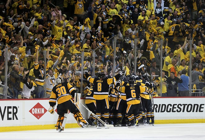 Pittsburgh Penguins players and fans celebrate after the Penguins' Chris Kunitz scores a game winning goal in the second overtime period of Game 7 in the NHL hockey Stanley Cup Eastern Conference finals against the Ottawa Senators, Thursday, May 25, 2017, in Pittsburgh. The Penguins won 3-2. (AP Photo/Keith Srakocic)
