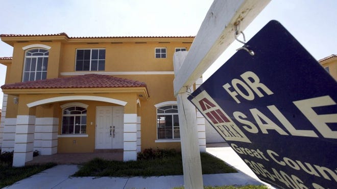 A ‘For Sale’ sign sits in front of a new home in Miami. The housing market sent mixed messages in Palm Beach County in September, with price growth softening as demand for low-priced properties stays red hot. (Getty Images)