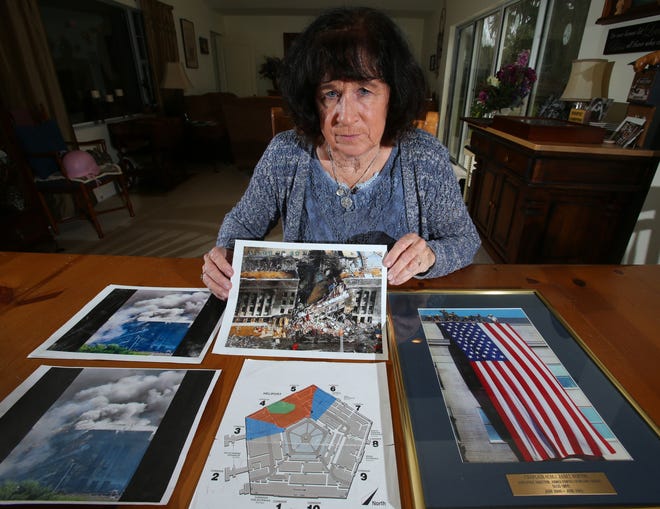 U.S. Army Col. Janet Horton, a retired military chaplain of 28 years, poses at her home in Ocala on March 23 with pictures of the Pentagon from the Sept. 11 terrorist attack. The plane struck the south side of the building where her office was, but she had been called away to get dental X-rays. [Bruce Ackerman / Gatehouse Media]