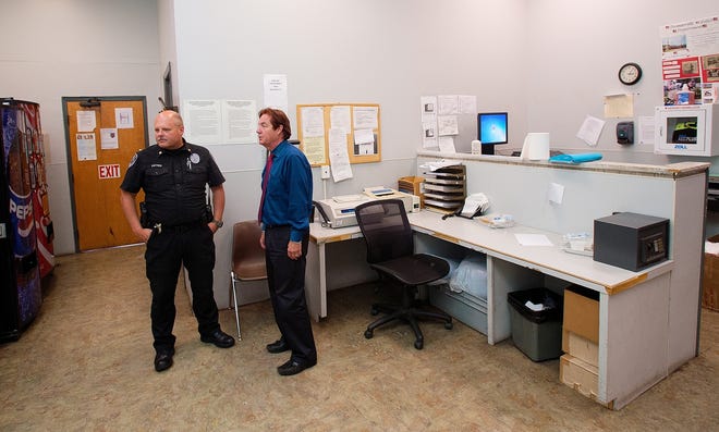 Maj. Mark Kattner of the Thomasville Police Department and Thomasville City Manager Kelly Craver stand in the small patrol arrest processing room at the police department. To keep suspects from different arrests separated, often the officers have to keep suspects in potrol cars outside until the space is available. [Donnie Roberts/The Dispatch]
