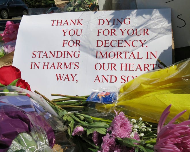 A sign of thanks rests against a traffic light pole at a memorial outside the transit center in Portland, Ore. on Saturday, May 27, 2017. People stopped with flowers, candles, signs and painted rocks for two bystanders who were stabbed to death Friday, while trying to stop a man who was yelling anti-Muslim slurs and acting aggressively toward two young women, including one wearing a Muslim head covering, on a light-trail train in Portland. Suspect Jeremy Joseph Christian, 35, was booked on suspicion of murder and attempted murder in the attack and will make a first court appearance Tuesday. (AP Photo/Gillian Flaccus)